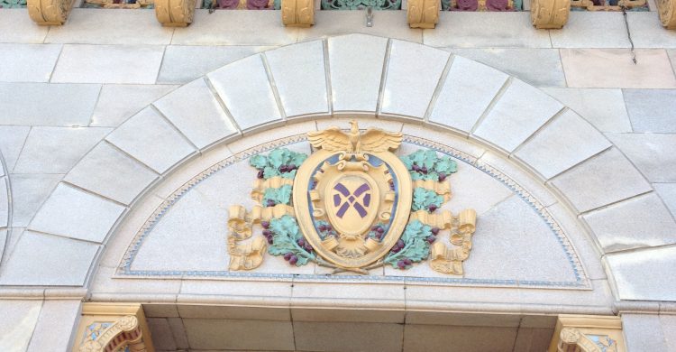 A close-up of gold decorative elements on a white building